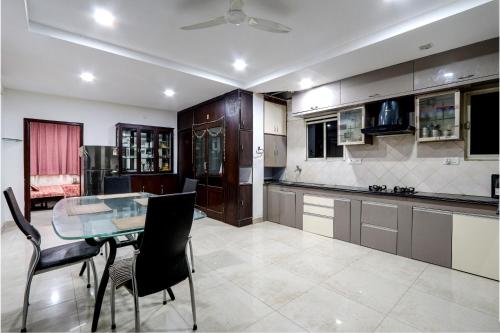 a kitchen with a glass table and some chairs at Fortune pent House Villa in Hyderabad