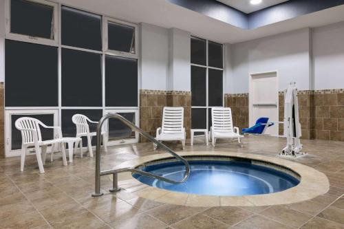 a spa room with a hot tub and chairs at La Quinta Inn & Suites by Wyndham Ft Worth-Burleson in Burleson