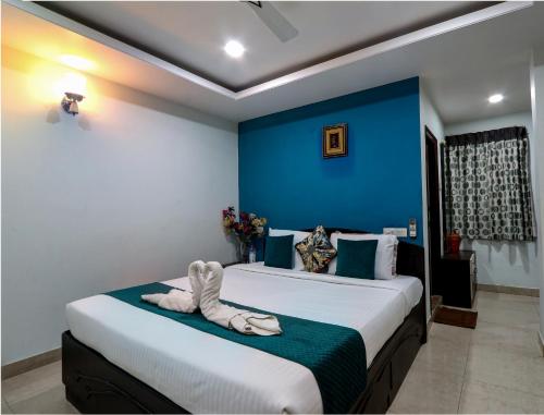 Duas camas num quarto com uma parede azul em Fortune pent House Villa em Hyderabad