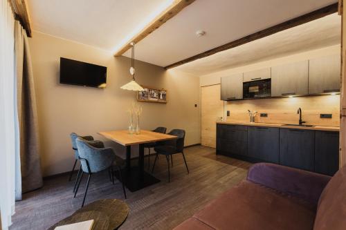 a living room and kitchen with a table and chairs at TANOVINUM Apartments in Villandro