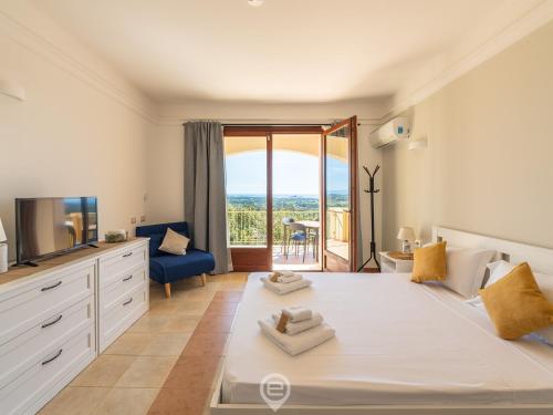 a bedroom with a large white bed and a tv at Casa Oskar in Is Molas 