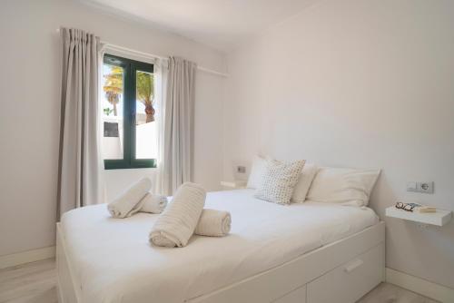 - une chambre blanche avec un grand lit blanc et des oreillers blancs dans l'établissement Lanzahost Casa Sunny Seafront, à Costa Teguise