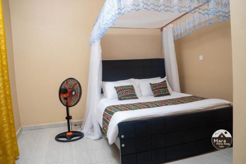 a bedroom with a canopy bed with a fan at Mara Home Away in Lira, Uganda in Lira