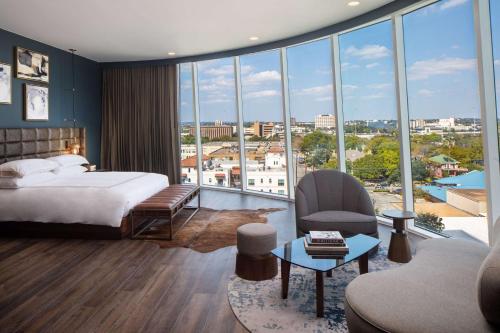 a bedroom with a bed and a view of a city at Thompson San Antonio - Riverwalk, by Hyatt in San Antonio