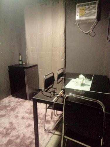 een kamer met een bureau, een telefoon en airconditioning bij marivic apartment and staycation in Davao City