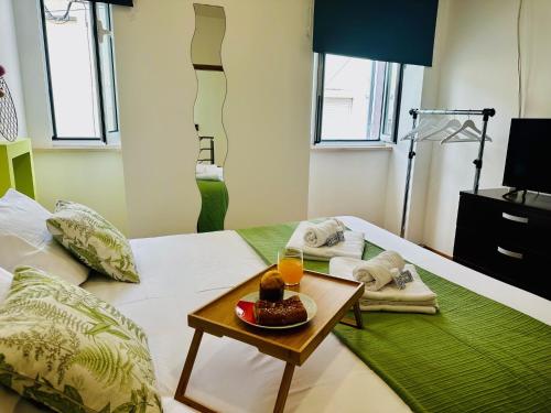 a room with a bed with a tray of food on it at Nênê House - Casa de Praia by Férias em Figueira in Figueira da Foz