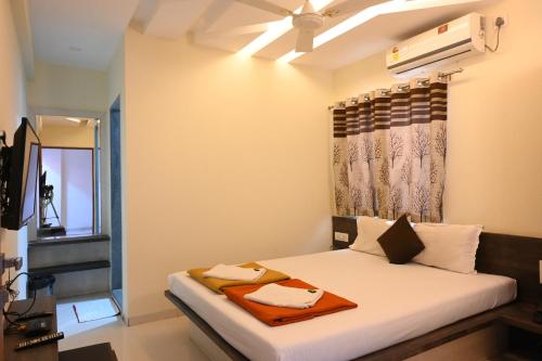 a bedroom with a bed with a ceiling fan at Hotel Ramkrishna Inn in Kolhapur