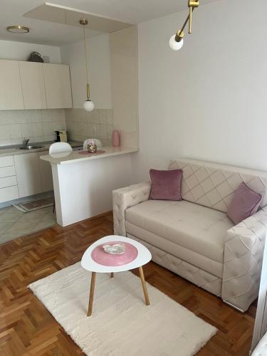 a living room with a couch and a table at Apartman Nini in Kraljevo