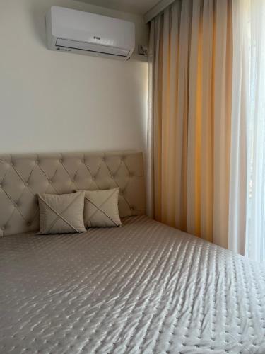 a bed with two pillows sitting next to a window at Apartman Nini in Kraljevo