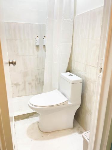 a white bathroom with a toilet and a shower at Caleo Boracay Island Station 3 in Boracay
