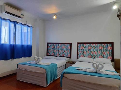 1 dormitorio con 2 camas y toallas. en Big Brother Condotel, en Puerto Princesa City