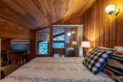 a bedroom with a bed in a room with wooden walls at 98 Elk Horn in Whitefish