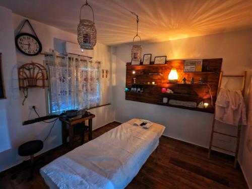 a living room with a bed and a clock on the wall at bali carmel zimmer & spa in Dāliyat el Karmil