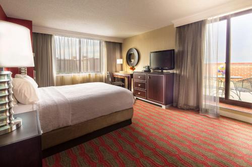 une chambre d'hôtel avec un lit et une télévision dans l'établissement LaGuardia Plaza Hotel, à Queens