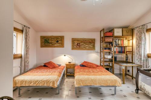 a bedroom with two beds and a book shelf at Schickes Haus am Montgrí in Torroella de Montgrí