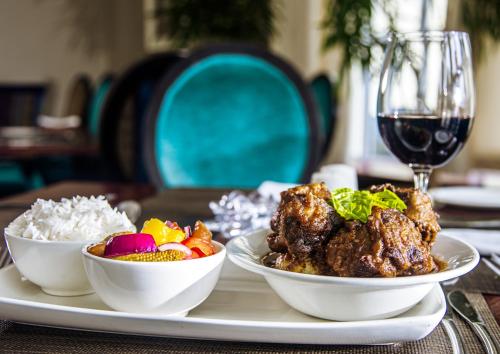 a table with two plates of food and a glass of wine at Hemingways Hotel in East London