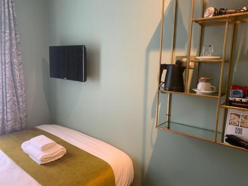 ロンドンにあるブルームズベリー パレス ホテルのベッドルーム1室(ベッド1台、壁掛けテレビ付)