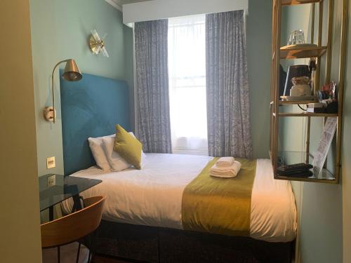 sypialnia z łóżkiem z lustrem i oknem w obiekcie Bloomsbury Palace Hotel w Londynie