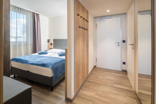 a bedroom with a bed and a mirror at Best Western Hotel München Airport in Erding