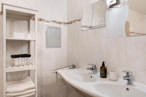 a white bathroom with a sink and a mirror at Ferienwohnung Obsthof Fieß in Oberkirch