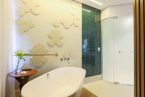a bathroom with a white tub and a shower at Radisson São Paulo Paulista in Sao Paulo