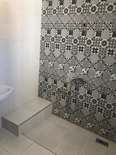 bagno con doccia e parete piastrellata di Riad Malak a Meknès