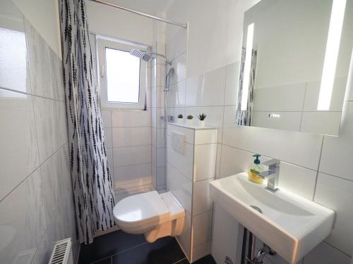 a white bathroom with a sink and a toilet at Modern Apartment in Schwarzenbek in Schwarzenbek