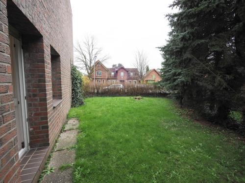 a yard with a brick building and a house at Modern Apartment in Schwarzenbek in Schwarzenbek