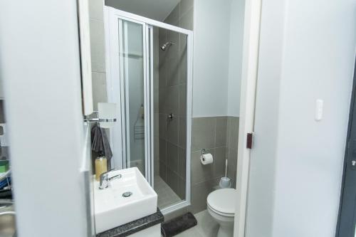 uma casa de banho com um lavatório e um WC em The Cozy Traveller em Gqeberha