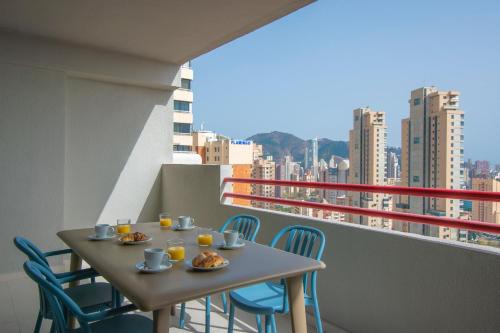 a table with plates of food on a balcony at Pierre & Vacances Benidorm Levante - Adults Recommended in Benidorm