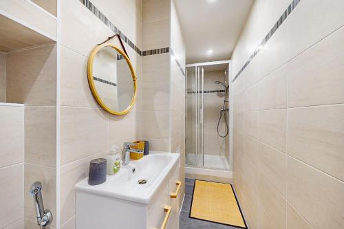 W białej łazience znajduje się umywalka i lustro. w obiekcie Chambre dans un manoir au bord de l'Yonne près de Sens w mieście Villeperrot