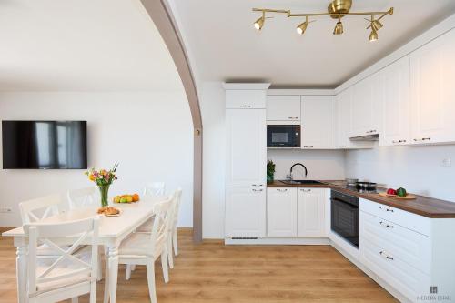 a kitchen with white cabinets and a table and chairs at Hedera Estate, Hedera A9 in Dubrovnik