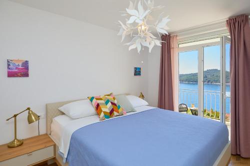 a bedroom with a bed and a large window at Hedera A9 in Dubrovnik