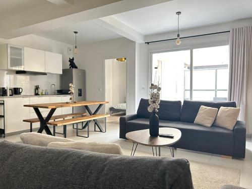 un salon avec un canapé bleu et une table dans l'établissement Chic in Paris - Oberkampf, à Paris