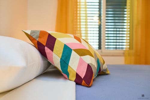 a colorful pillow sitting on top of a bed at Hedera Estate, Hedera A9 in Dubrovnik