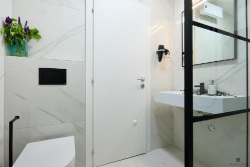 baño blanco con ducha y lavamanos en Hedera A9 en Dubrovnik