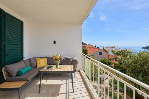 a patio with a couch and a table on a balcony at Hedera Estate, Hedera A9 in Dubrovnik