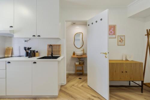 a kitchen with white cabinets and a mirror at Felp Santa Maria 1 in Setúbal