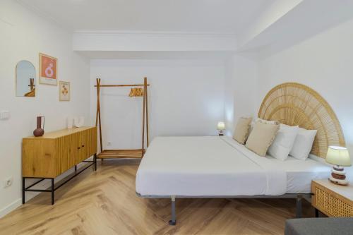 a bedroom with a large white bed and a wooden floor at Felp Santa Maria 1 in Setúbal