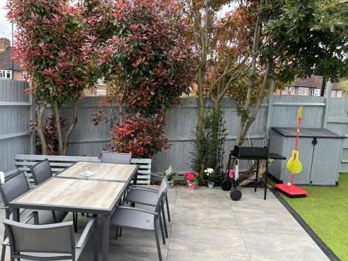a patio with a table and chairs and a piano at Brand New Big House with garden and free parking in Brentford