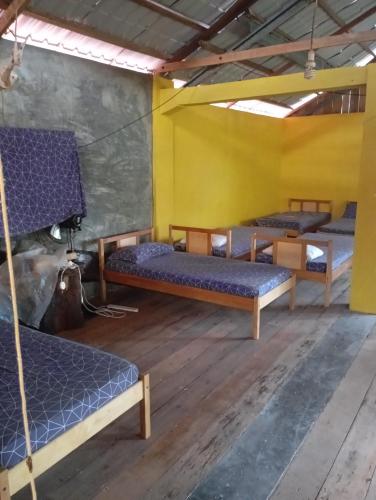 a room with three bunk beds in a building at sunrise seasports in Iboih
