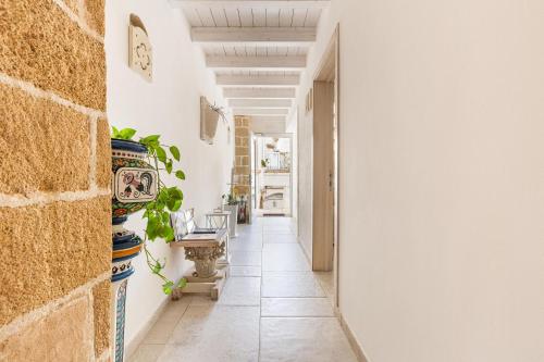 a hallway with a table and a clock on the wall at Clara Domus in Gallipoli