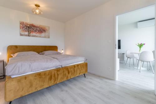 a bedroom with a bed and a dining room at Cozy apartment near city centrum and Bratislava airport in Prievoz