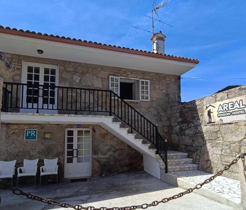 un edificio con una escalera delante de él en Pensión Rural para Peregrinos "AREAL", en Padrón