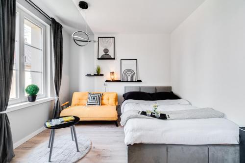 a bedroom with a bed and an orange chair at Apartamenty Stylove in Opole
