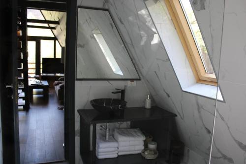 a bathroom with a sink and a window in a room at Valea Mosului - Cozy A Frame in Petroşani