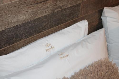 a close up of two white pillows on a bed at Valea Mosului - Cozy A Frame in Petroşani
