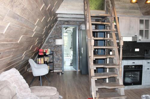 a living room with a spiral staircase in a tiny house at Valea Mosului - Cozy A Frame in Petroşani