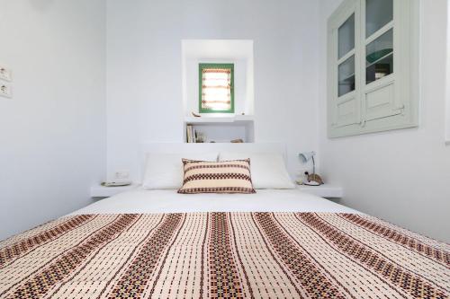 Habitación blanca con cama grande con almohada en Nymph Klido, en Kanakis