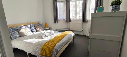 um quarto com uma cama com um cobertor amarelo em Bright & Chilled DB room with own bathroom! em Londres